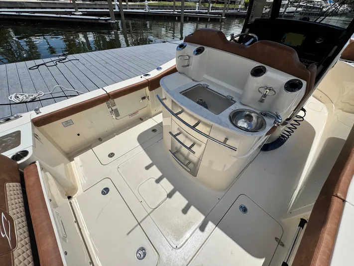  Yacht Photos Pics 2024 Scout 277 LXF boat interior with seating and sink at dock.