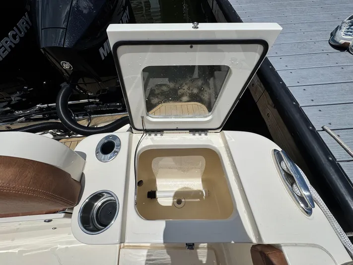  Yacht Photos Pics 2024 Scout 277 LXF boat with open storage compartment and Mercury engine.