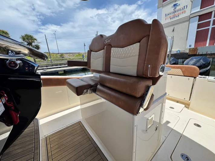  Yacht Photos Pics 2024 Scout 277 LXF boat interior with luxurious brown seating and modern dashboard.
