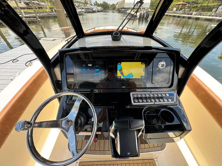  Yacht Photos Pics 2024 Scout 277 LXF boat dashboard with steering wheel and navigation screens.