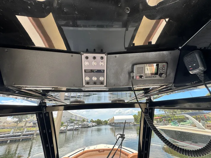  Yacht Photos Pics 2024 Scout 277 LXF boat dashboard with navigation controls and scenic marina view.