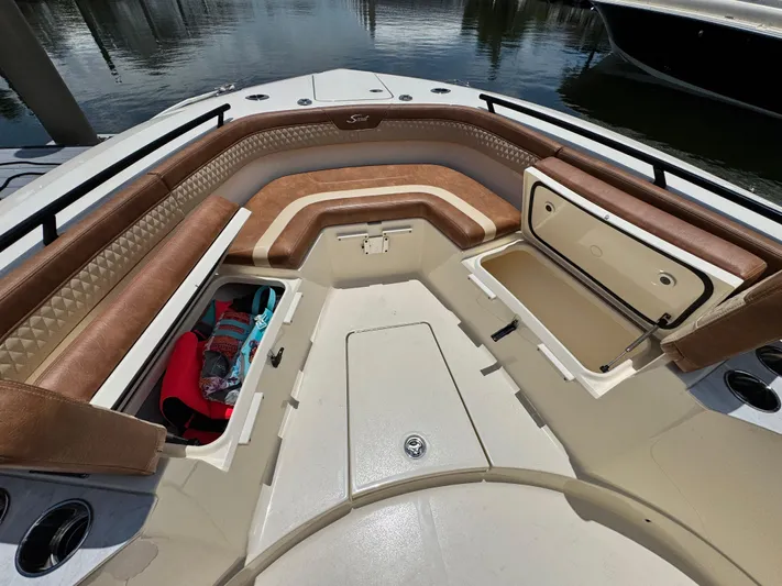  Yacht Photos Pics 2024 Scout 277 LXF boat interior with brown seating and storage compartments.