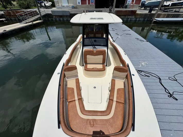  Yacht Photos Pics 2024 Scout 277 LXF boat docked, featuring spacious seating and sleek design.