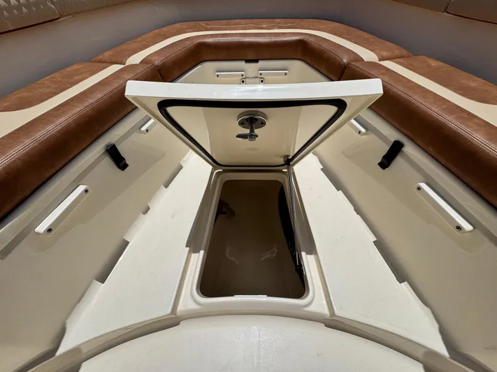  Yacht Photos Pics 2024 Scout 277 LXF boat storage compartment with open hatch and cushioned seating.