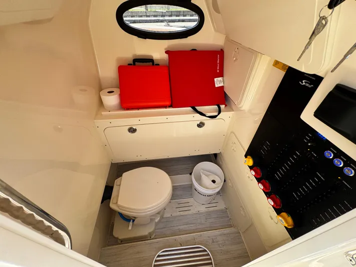  Yacht Photos Pics 2024 Scout 277 LXF boat interior with toilet, storage, and control panel.