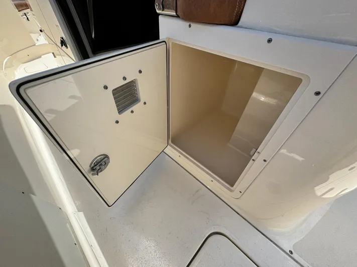  Yacht Photos Pics Open storage compartment on 2024 Scout 277 LXF boat, showcasing interior space.