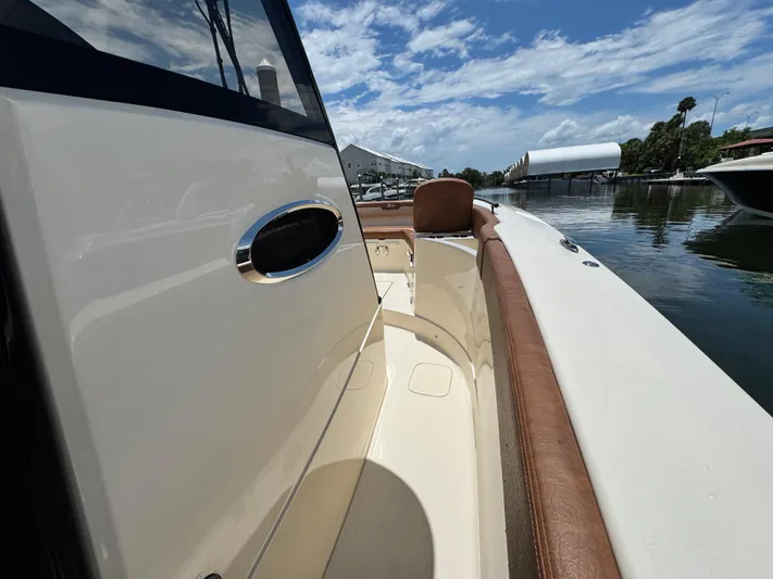 Yacht Photos Pics 2024 Scout 277 LXF boat interior with brown seating, docked by calm waters.