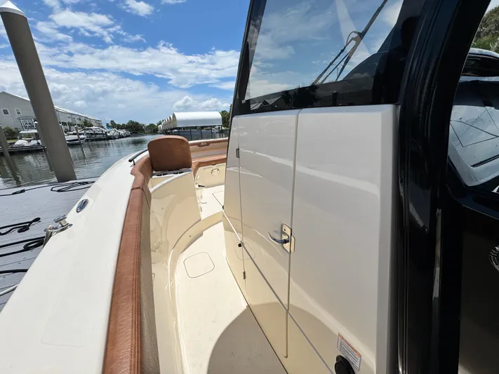  Yacht Photos Pics 2024 Scout 277 LXF boat docked, showcasing sleek design and luxurious seating.