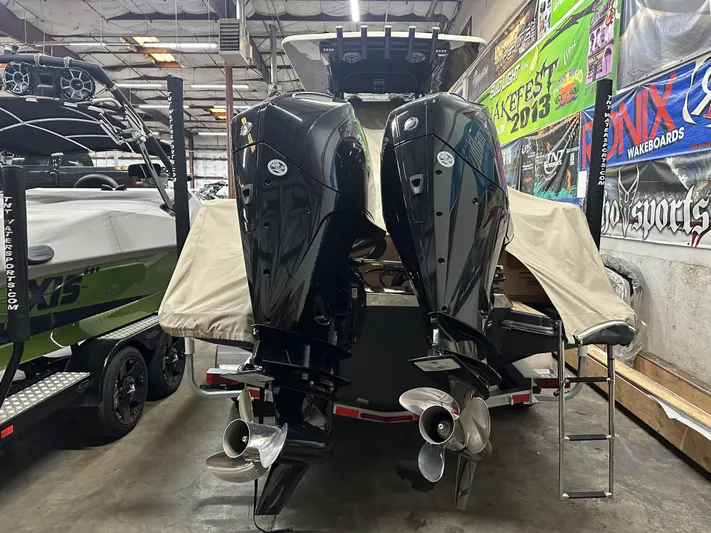  Yacht Photos Pics 2024 Scout 277 LXF boat with dual outboard motors in a showroom.