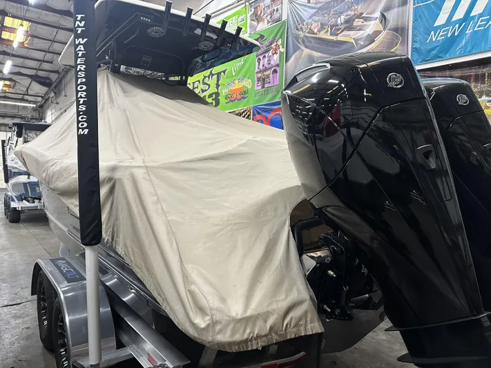  Yacht Photos Pics 2024 Scout 277 LXF boat covered in a garage with visible outboard motors.