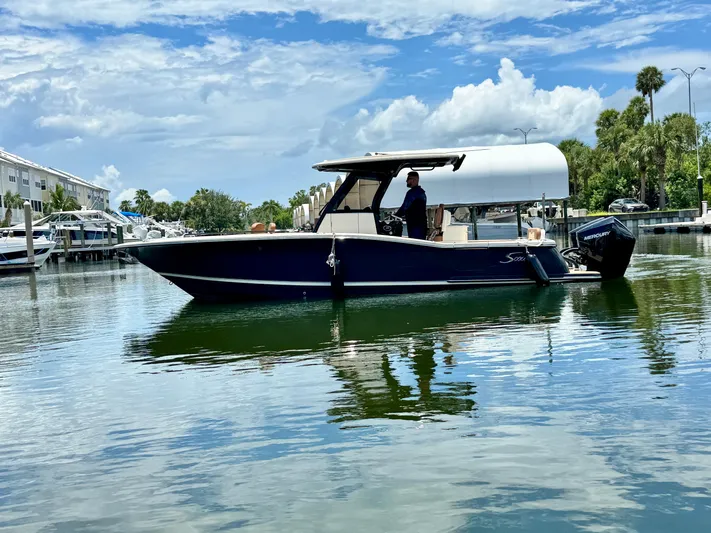  Yacht Photos Pics 2024 Scout 277 LXF boat on calm water under a partly cloudy sky.