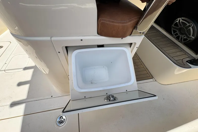  Yacht Photos Pics 2024 Scout 277 LXF boat with open storage compartment and cushioned seating.