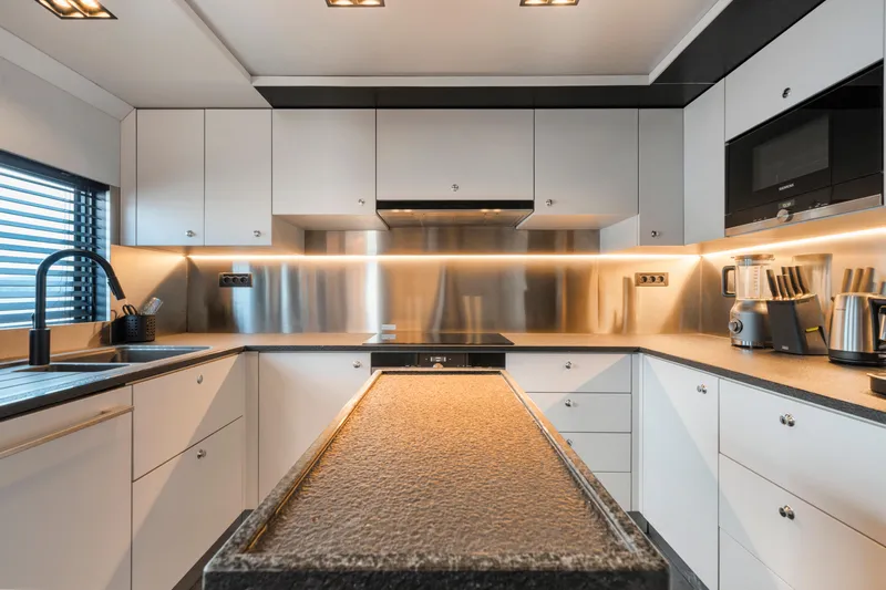 Ice Yacht Photos Pics Modern yacht kitchen with sleek white cabinets, stainless steel appliances, and ambient lighting, Soyaslan 78', 2024.