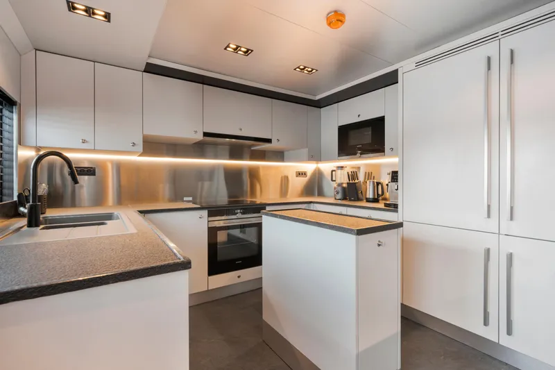Ice Yacht Photos Pics Modern yacht kitchen with sleek white cabinetry, stainless steel appliances, and ambient lighting, 2024 Soyaslan 78'.