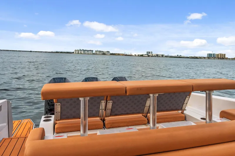  Yacht Photos Pics 2021 Aviara AV36 OB boat with tan seating, overlooking a calm waterfront cityscape.