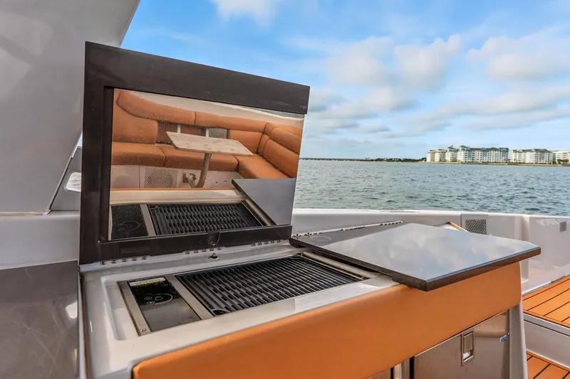  Yacht Photos Pics 2021 Aviara AV36 OB yacht with outdoor grill and seating area, overlooking waterfront buildings.