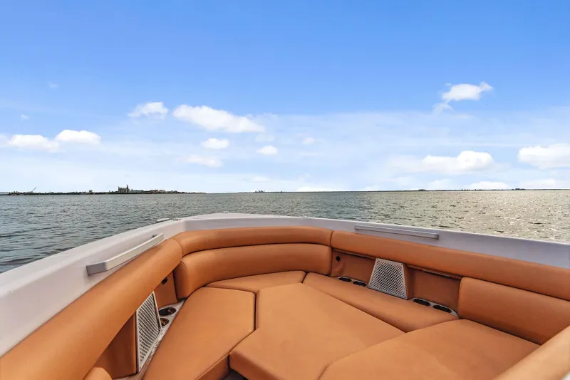  Yacht Photos Pics 2021 Aviara AV36 OB boat interior with tan seating, overlooking calm waters and blue sky.