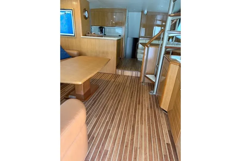 Killin Time Yacht Photos Pics Interior of 2003 Viking 65 Convertible Enclosed Bridge with wooden flooring and modern furnishings.