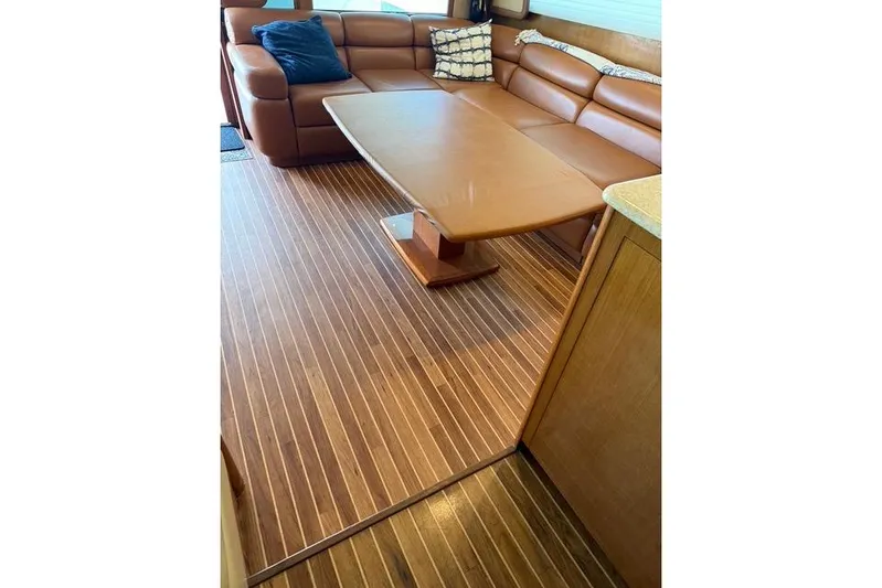 Killin Time Yacht Photos Pics Luxurious interior of 2003 Viking 65 Convertible Enclosed Bridge with leather seating and wooden flooring.