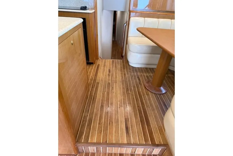 Killin Time Yacht Photos Pics Interior of 2003 Viking 65 Convertible Enclosed Bridge with wooden flooring and seating area.