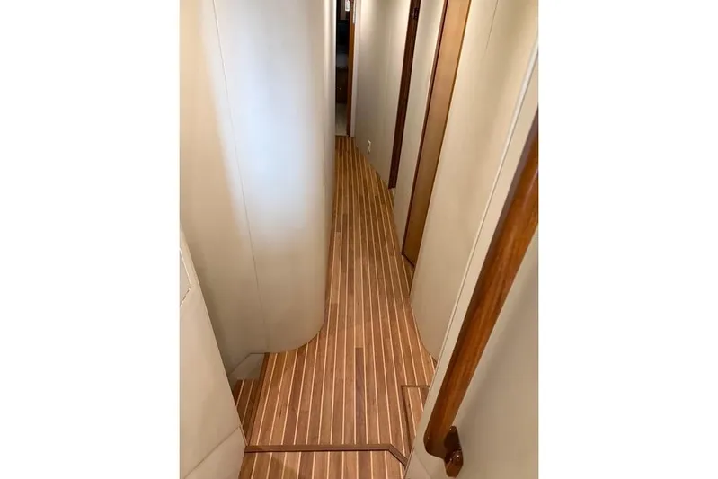Killin Time Yacht Photos Pics Narrow hallway with wooden flooring inside a 2003 Viking 65 Convertible Enclosed Bridge yacht.