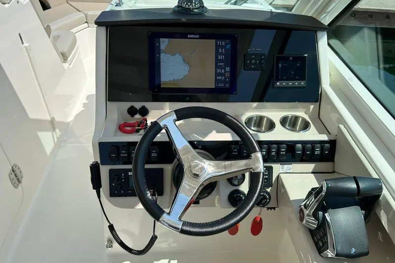2023 Boston Whaler 280 Vantage @ Puerto Vallarta Yacht Photos Pics 2023 Boston Whaler 280 Vantage helm with steering wheel, navigation display, and controls.
