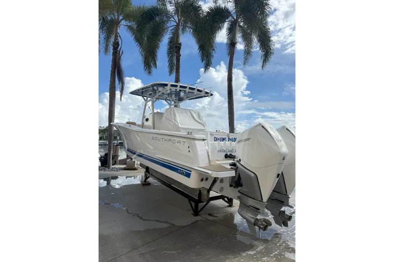 Chasing Palooza Yacht Photos Pics 2024 Southport 30 FE boat with dual Mercury engines, docked under palm trees.