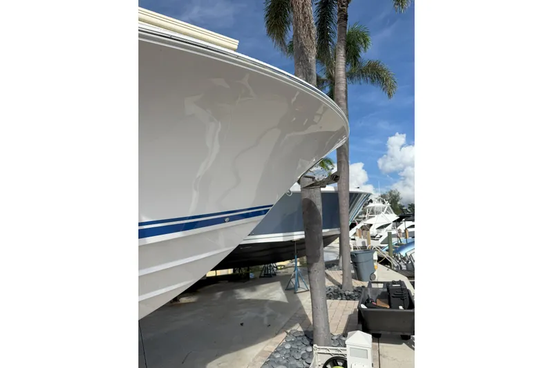 Chasing Palooza Yacht Photos Pics 2024 Southport 30 FE boat docked under palm trees, clear sky background.