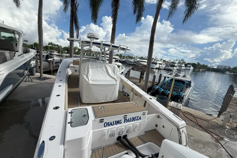 Chasing Palooza Yacht Photos Pics 2024 Southport 30 FE boat docked at marina with palm trees and cloudy sky.