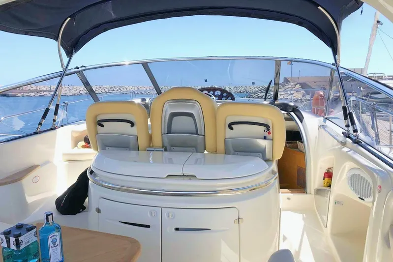  Yacht Photos Pics 2006 Cranchi Mediterranee 47 yacht interior with helm and seating, docked by the sea.