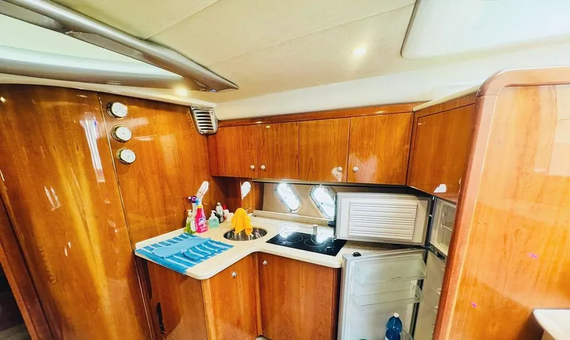  Yacht Photos Pics Interior of 2006 Cranchi Mediterranee 47 yacht with wooden cabinetry and compact kitchen area.