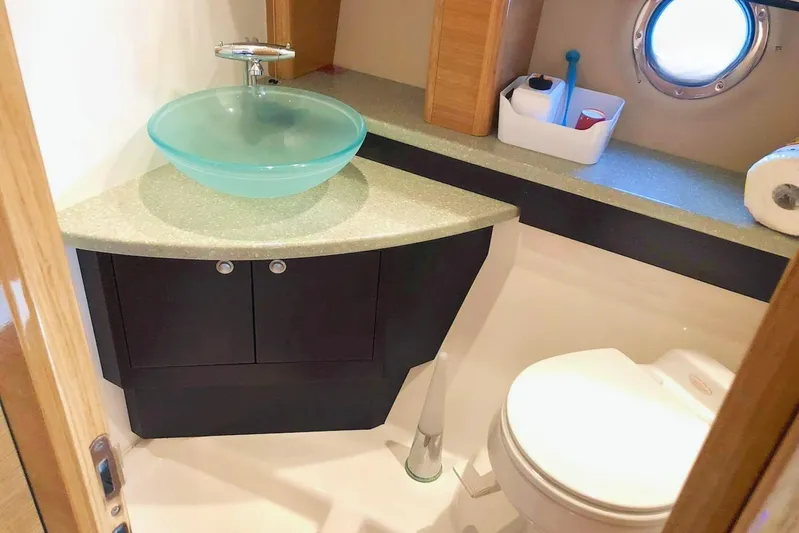  Yacht Photos Pics Luxury bathroom in 2006 Cranchi Mediterranee 47 yacht with modern glass sink and porthole window.