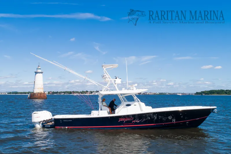  Yacht Photos Pics 2016 Regulator 41 boat cruising near a lighthouse on a sunny day.