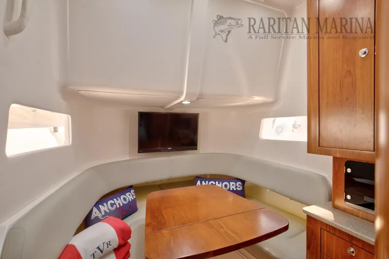  Yacht Photos Pics 2016 Regulator 41 boat interior with cozy seating, wooden table, and mounted TV.