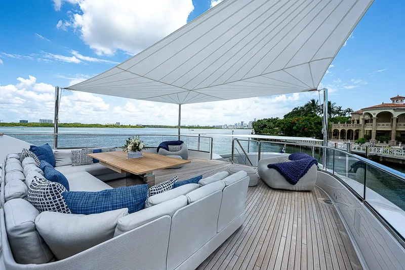 The Wolf Yacht Photos Pics Luxurious 2023 Sanlorenzo SD118 yacht deck with elegant seating and scenic waterfront view.
