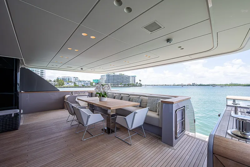 The Wolf Yacht Photos Pics Luxurious 2023 Sanlorenzo SD118 yacht deck with elegant dining area and scenic waterfront view.