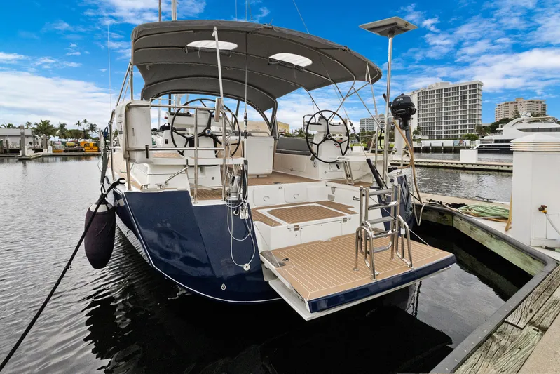 Beatrice Yacht Photos Pics 2021 Jeanneau Sun Odyssey 51 Performance yacht docked at marina, featuring dual steering wheels.