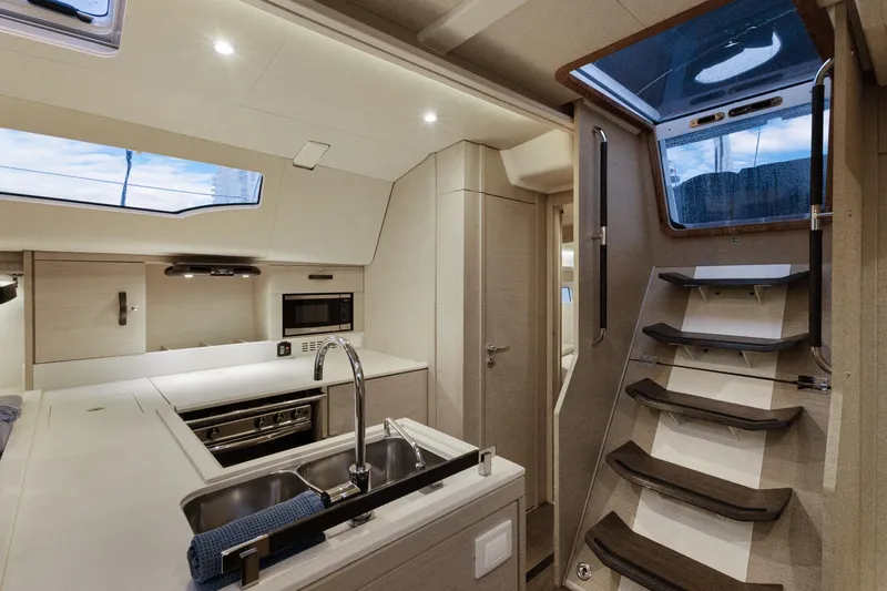 Beatrice Yacht Photos Pics Modern interior of 2021 Jeanneau Sun Odyssey 51 Performance yacht kitchen and stairs.
