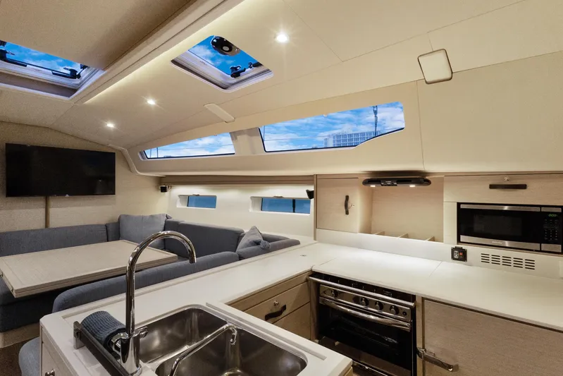 Beatrice Yacht Photos Pics Luxurious interior of 2021 Jeanneau Sun Odyssey 51 Performance yacht with modern kitchen and seating area.