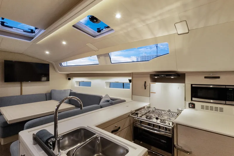 Beatrice Yacht Photos Pics Luxurious interior of 2021 Jeanneau Sun Odyssey 51 Performance yacht with modern kitchen and seating area.