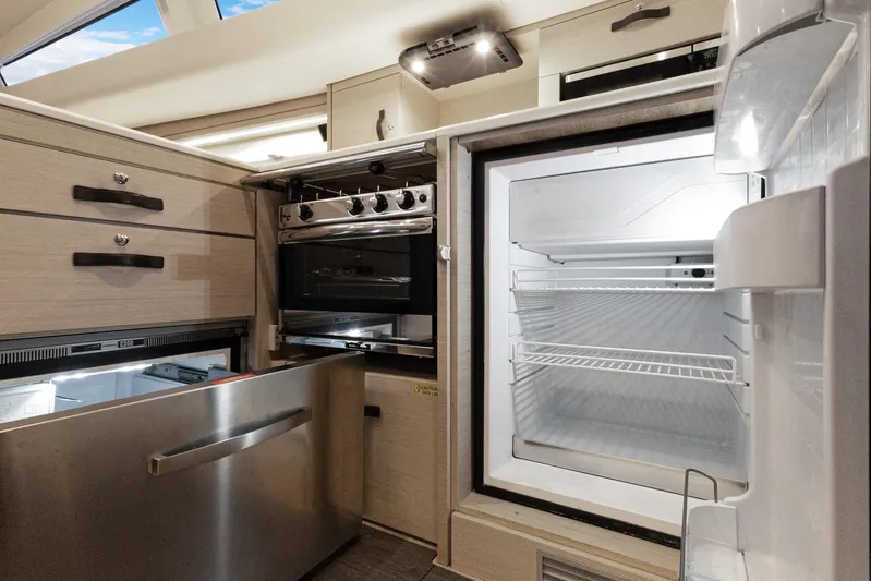 Beatrice Yacht Photos Pics Modern kitchen interior of Jeanneau Sun Odyssey 51 Performance yacht, featuring fridge and oven, 2021 model.