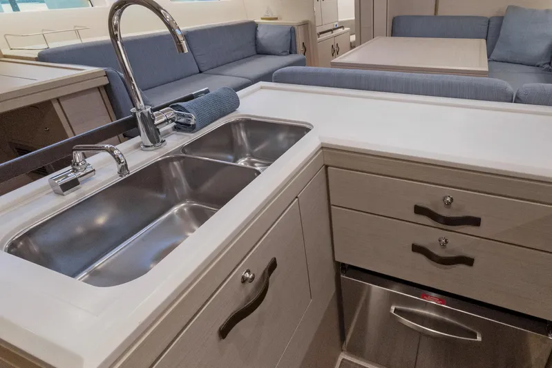 Beatrice Yacht Photos Pics Modern kitchen interior of 2021 Jeanneau Sun Odyssey 51 Performance yacht, featuring sleek sink and cabinetry.