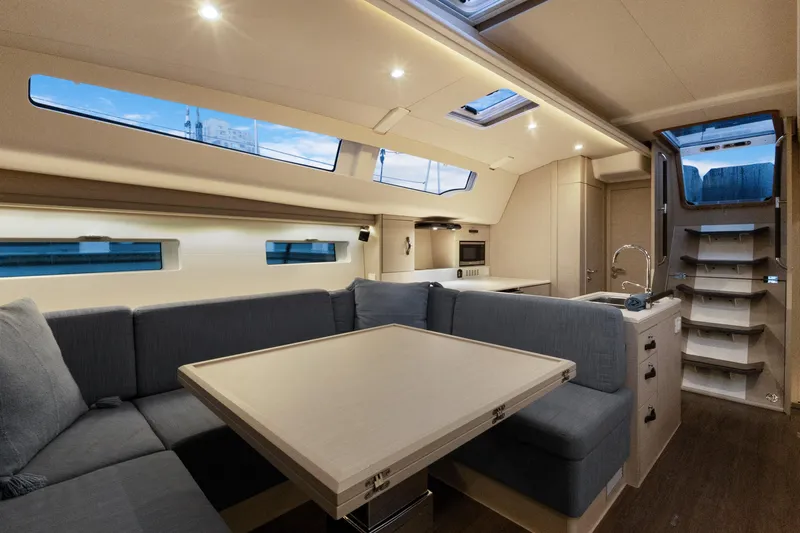 Beatrice Yacht Photos Pics Luxurious interior of 2021 Jeanneau Sun Odyssey 51 Performance yacht, featuring modern seating and kitchen.