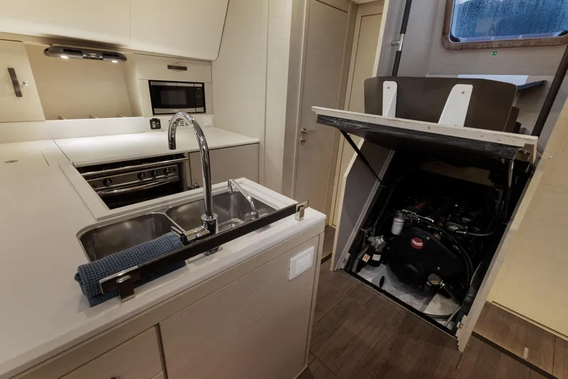 Beatrice Yacht Photos Pics Modern kitchen in 2021 Jeanneau Sun Odyssey 51 Performance yacht, featuring sleek appliances and engine access.