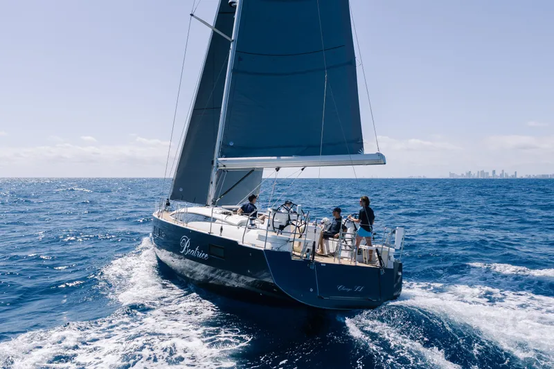 Beatrice Yacht Photos Pics 2021 Jeanneau Sun Odyssey 51 Performance sailing on open ocean with city skyline in background.