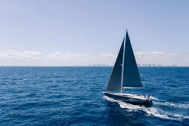 Beatrice Yacht Photos Pics 2021 Jeanneau Sun Odyssey 51 Performance sailing on open ocean with city skyline in background.