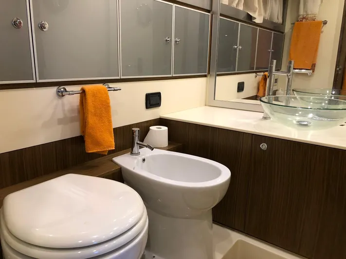  Yacht Photos Pics Luxury yacht bathroom with modern fixtures, glass sink, and orange towel. Riva Super Ego 68, 2006.