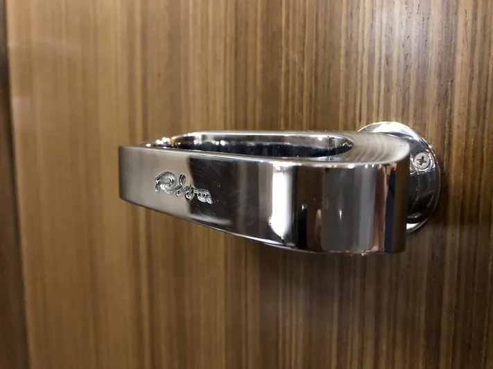  Yacht Photos Pics Chrome door handle on Riva Super Ego 68 yacht, 2006 model, against wood paneling.