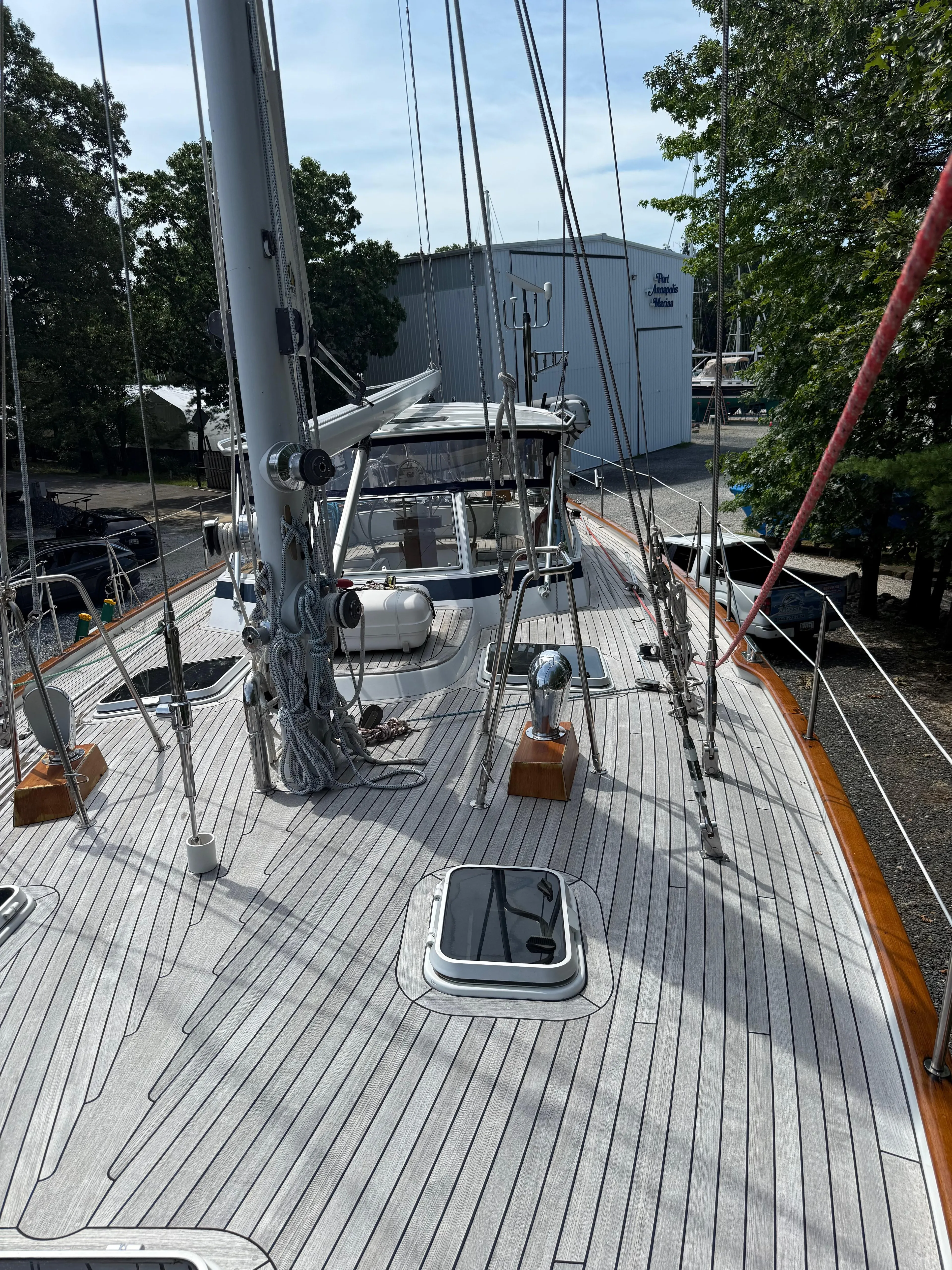 Pegasus Yacht Photos Pics 1984 Hallberg-Rassy 49 sailboat deck with rigging and hatches, docked near trees and buildings.