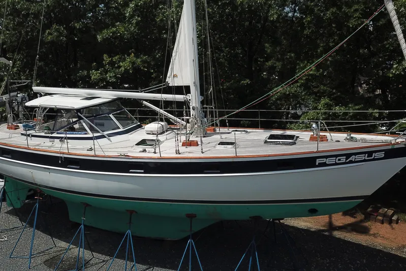 Pegasus Yacht Photos Pics 1984 Hallberg-Rassy 49 sailboat named Pegasus on stands, surrounded by trees.